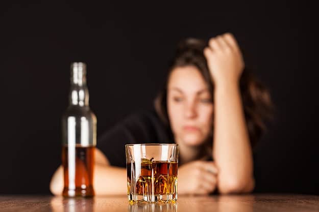 frustrated alcoholic with bottle of alcohol experiencing effects of alcohol on the brain