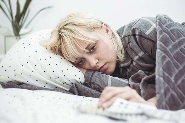 a woman in bed wondering can you mix depressants and opioids