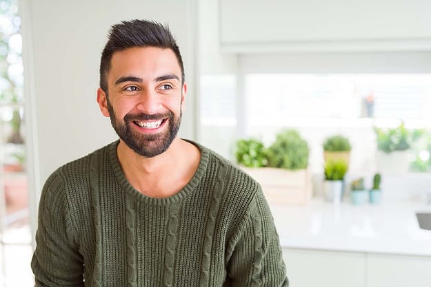 man smiling in his house learning about prospective addiction treatment in florida