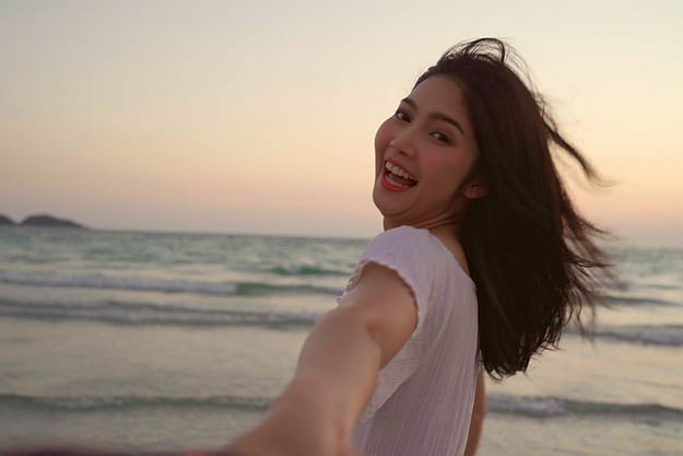 young woman smiling at the beach free from chemical dependency