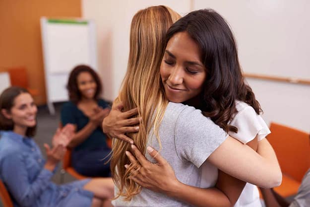 two women hugging to support each other during the Jacksonville women's rehab program