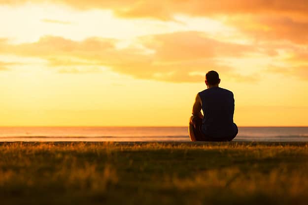 Man watching a sunset and thinking about the heroin addiction recovery rate