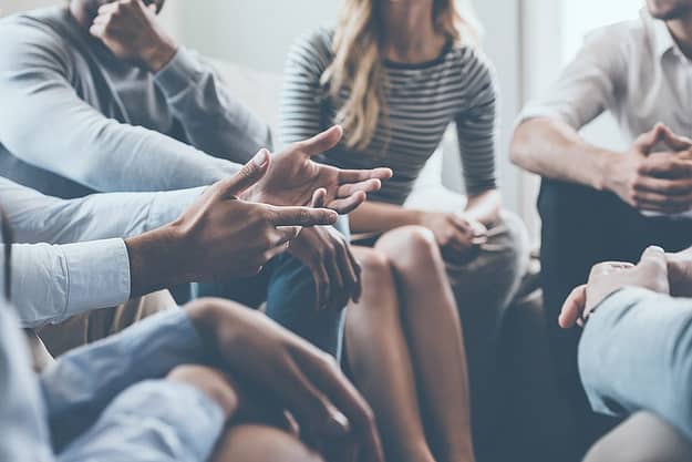 A group of people discuss dual diagnosis treatment programs