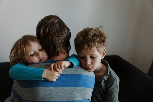 parent hugging their kids dealing with effects of suicide