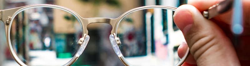 Blurry eyeglasses held up to the light, symbolizing how authenticity in healthcare branding is often overlooked or seen unclearly in marketing efforts.