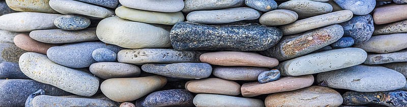 Colorful stones stacked tightly together, each supporting the others under pressure — symbolizing how authentic messaging in healthcare crisis communication builds a strong, trustworthy foundation when it matters most.