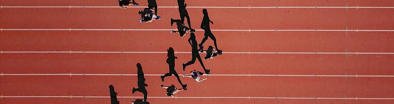 Track and field runners spread out on a track, symbolizing how healthcare marketing teams are evolving and moving forward together.