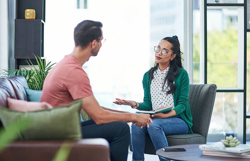 Person sits across from therapist, discussing different types of psychotherapy and their benefits
