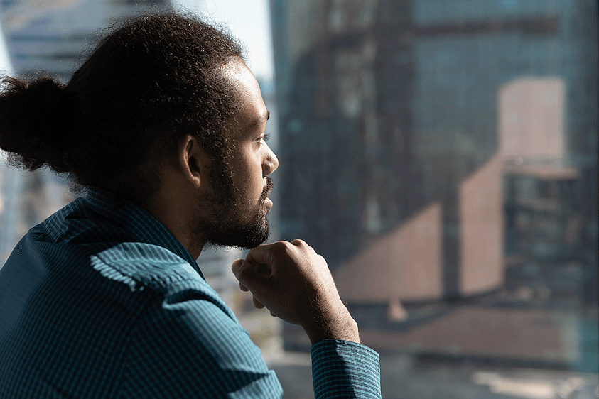 a young man looks sadly from a window wondering "why is heroin so addictive?"