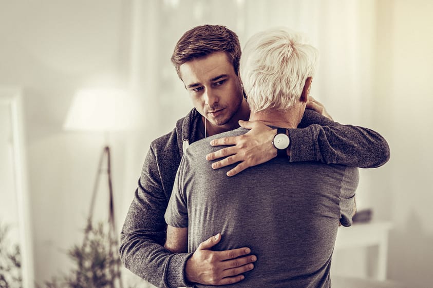 a person in group therapy gives a hug after asking what is trauma bonding