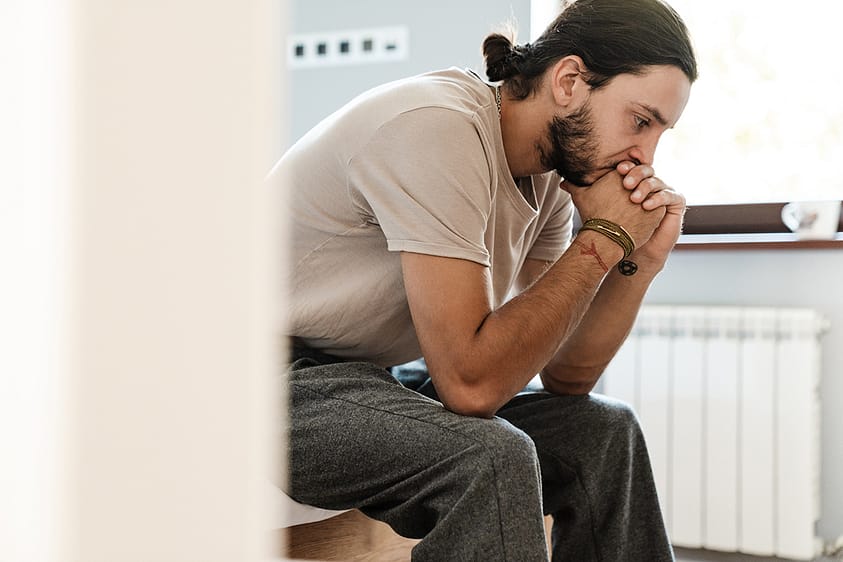 a man struggling with kratom addiction sits and thinks