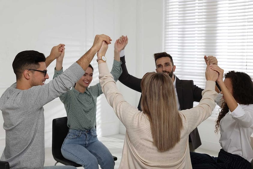Clients at a drug rehab near Orlando hold hands during group therapy