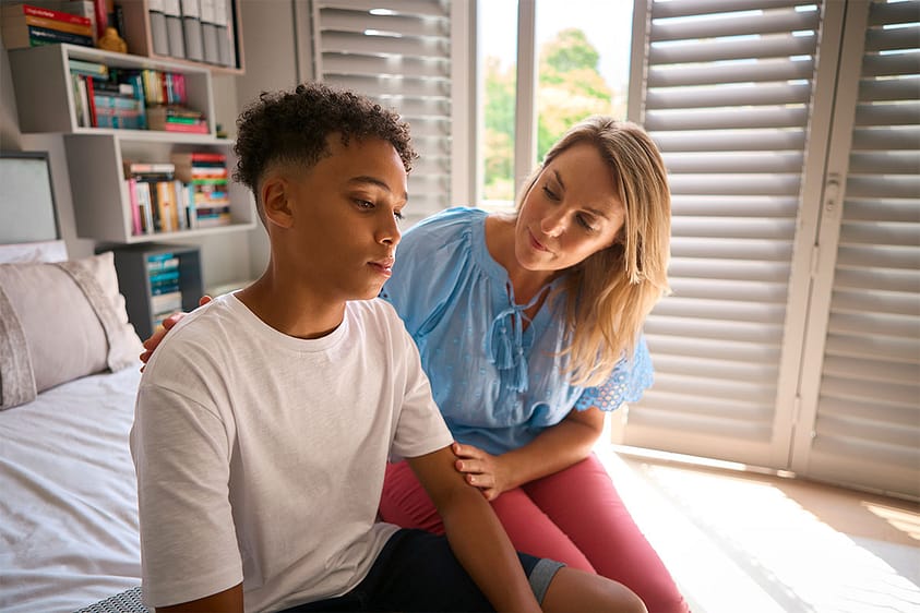 a mother comforts a teen who is showing signs of cocaine use