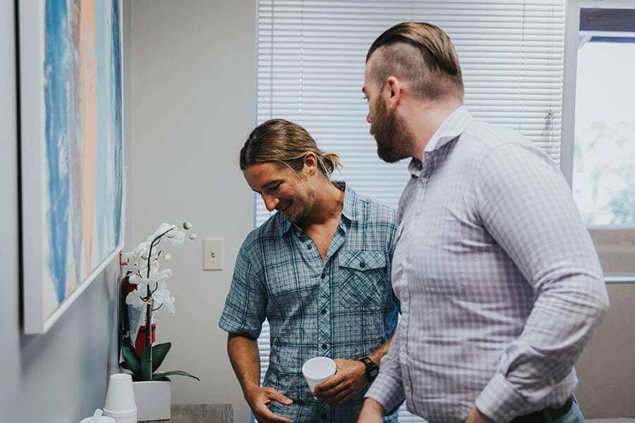 Two male patients laughing and making coffee