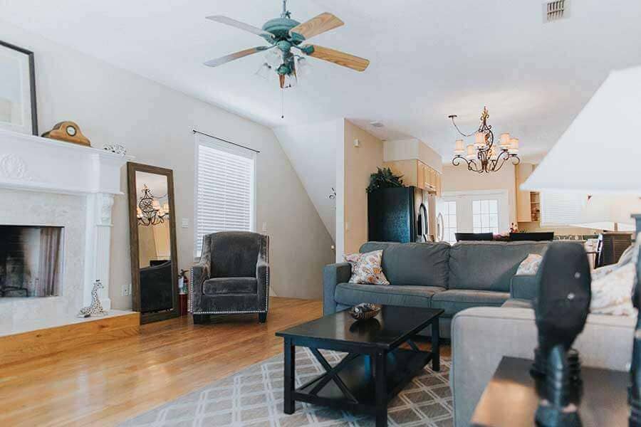 Living room with a grey couch and white fireplace in a drug addiction treatment house