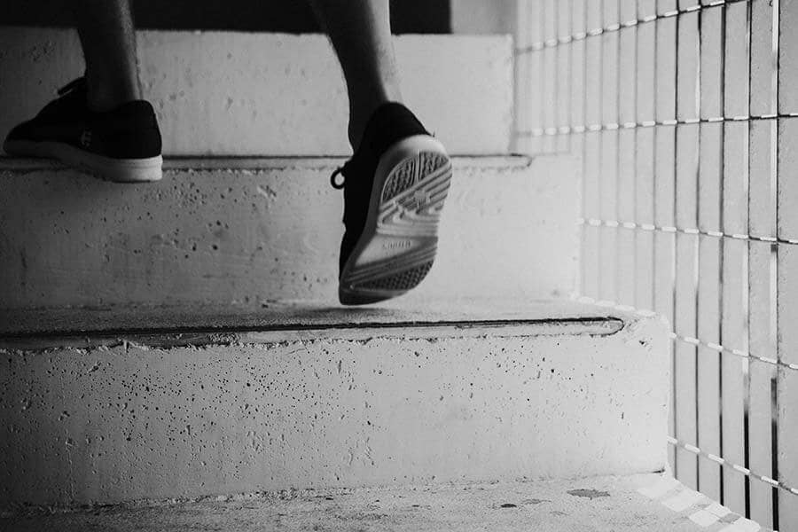 Man walking up cement stairs