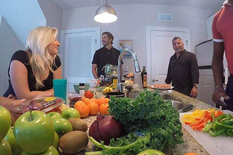 Patients in a drug rehab home laughing while preparing a meal